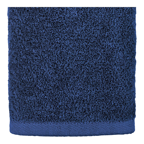 A close up of a navy blue hand towel with a white border.