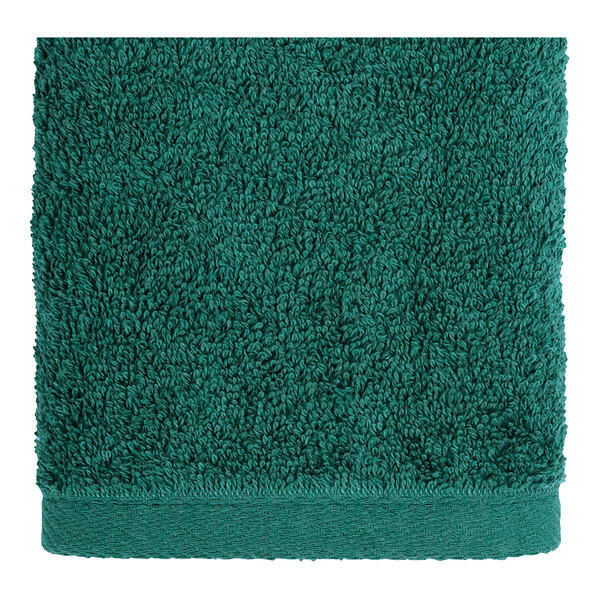 A white hand towel with a green border.