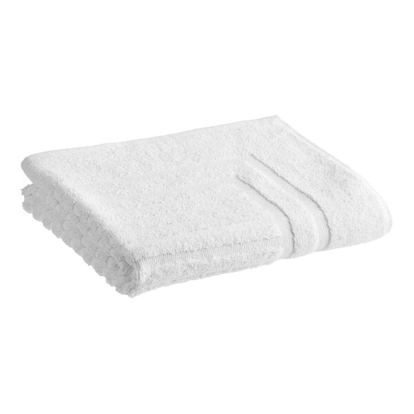 A folded white 1888 Mills Lotus terry bath mat on a white background.