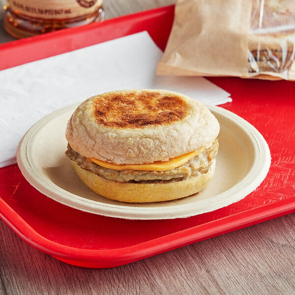 A Grand Prairie Sausage and Cheddar Whole Wheat Muffin breakfast sandwich on a plate.