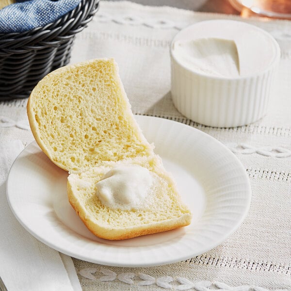 A white plate with a piece of bread with Miyoko's European-Style Cultured Vegan Butter on it.