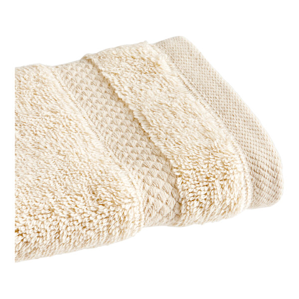 A white 1888 Mills Magnificence Pima Cotton washcloth folded on a white surface.