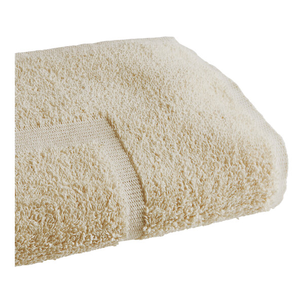 A beige 1888 Mills Fibertone bath mat with a patch on it.