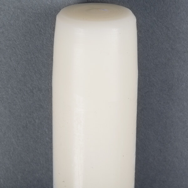 A 15 inch ivory Will & Baumer taper candle on a gray surface.