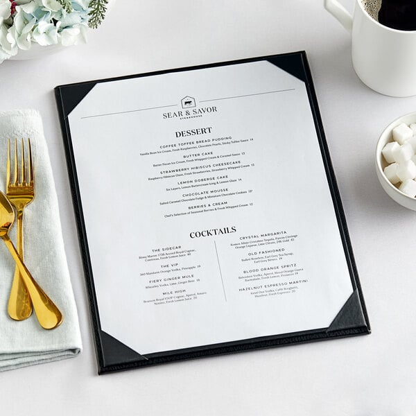 A black Acopa Prime vinyl menu board on a table with a white menu inside.