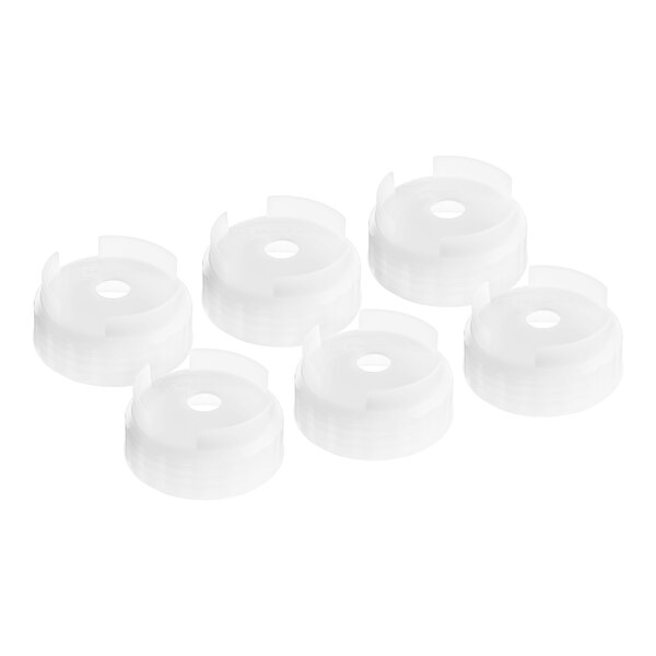 A stack of white plastic discs with San Jamar nozzle caps on top.