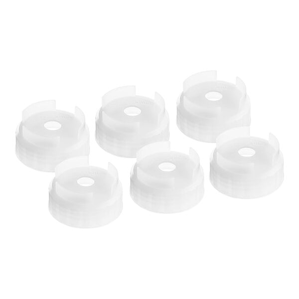 A group of white plastic circular San Jamar nozzle caps.