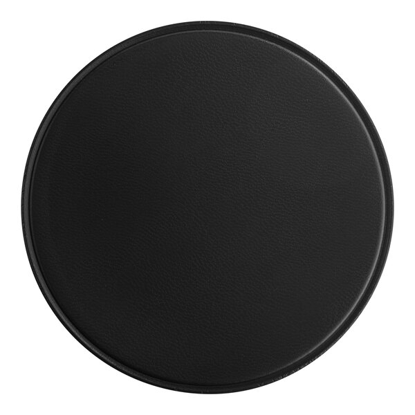A black round vinyl coaster on a table.