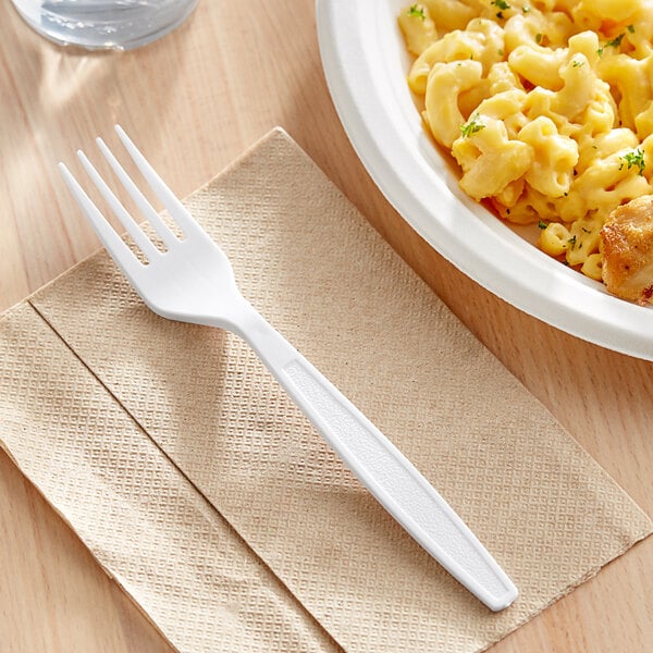 A plate of macaroni and cheese with a white plastic fork on a napkin.