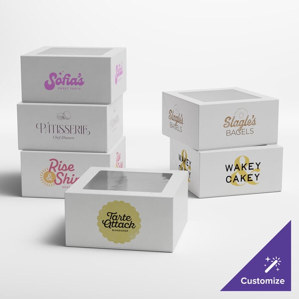 A set of white customizable auto-popup window cake and bakery boxes with various printed logos and designs.