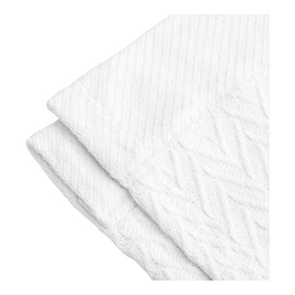 A close-up of a white herringbone knitted blanket.