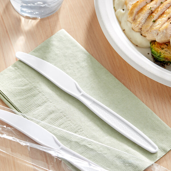 A white plastic knife wrapped in plastic.