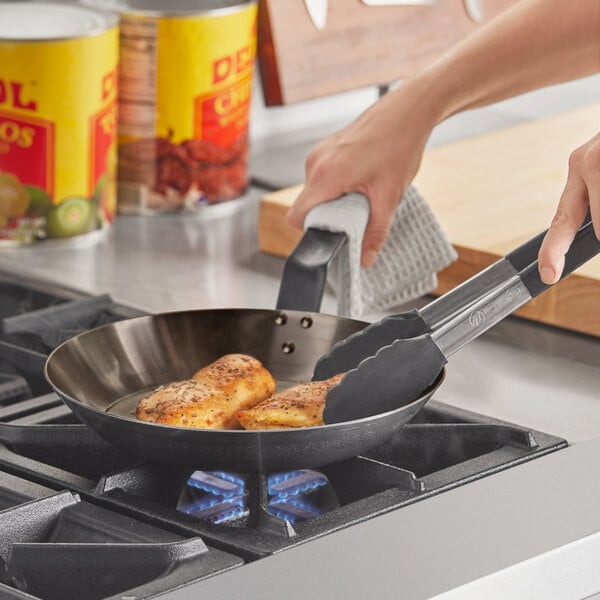 Fish fillets being cooked in a carbon steel pan