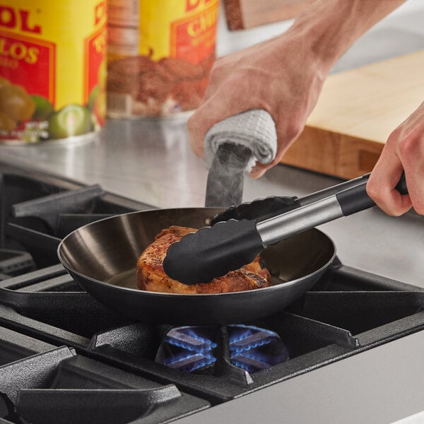 A person cooking food in a Choice carbon steel fry pan on a stove.