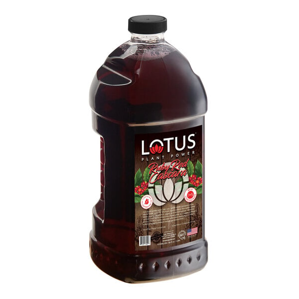 A large, clear plastic bottle filled with a dark red liquid and labeled 'Lotus Plant Power Ruby Red Cascara' with a black cap.
