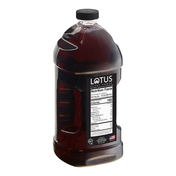A large, clear plastic bottle filled with a dark red liquid and labeled with nutrition facts and the brand name 'Lotus Plant Power.'