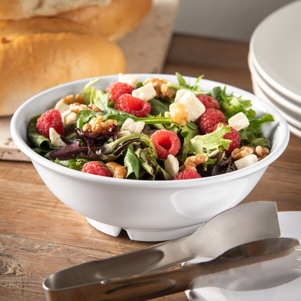 A white Carlisle melamine bowl filled with salad, raspberries, and nuts.