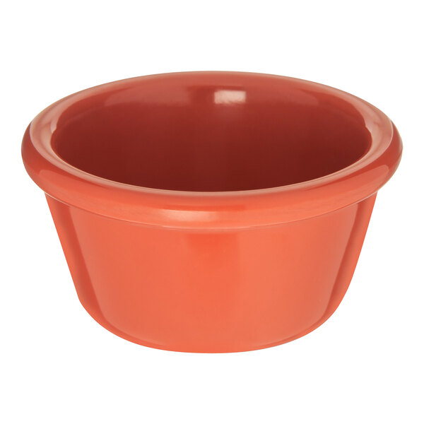 A close up of a Carlisle Sunset Orange smooth melamine ramekin.