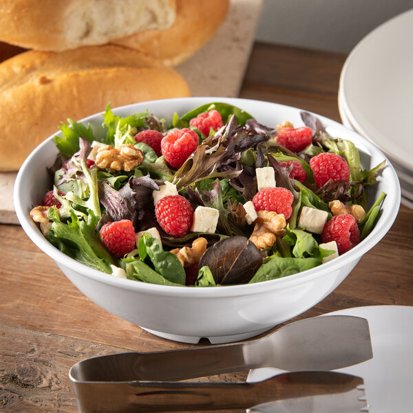 A white Carlisle melamine bowl filled with a salad with raspberries and nuts.