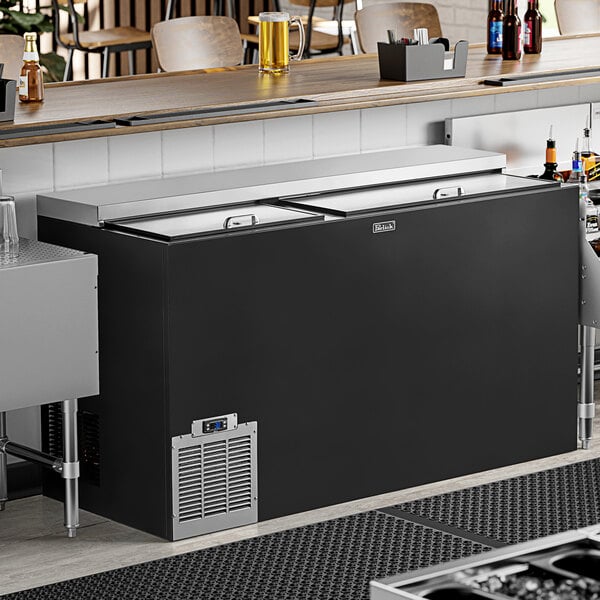 A black Perlick horizontal flat top bottle cooler on a counter.