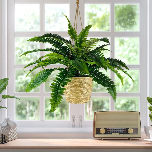 A close-up of a 30" artificial Boston fern in a hanging basket.
