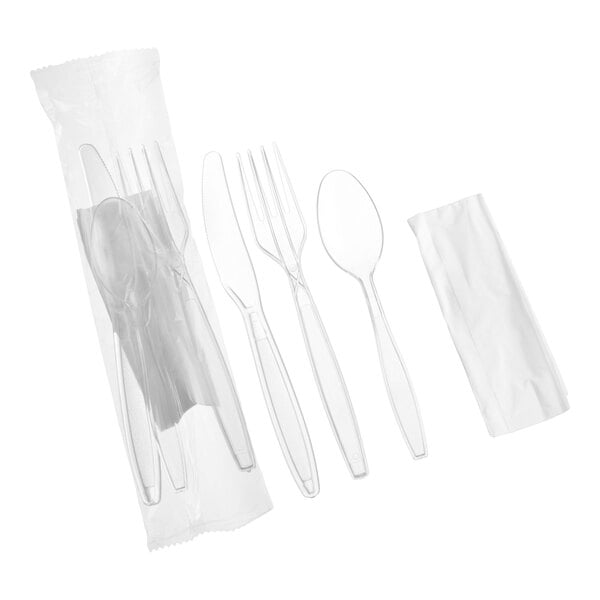 A set of clear heavy weight polystyrene plastic cutlery including a knife, fork, spoon, and a napkin, individually wrapped.