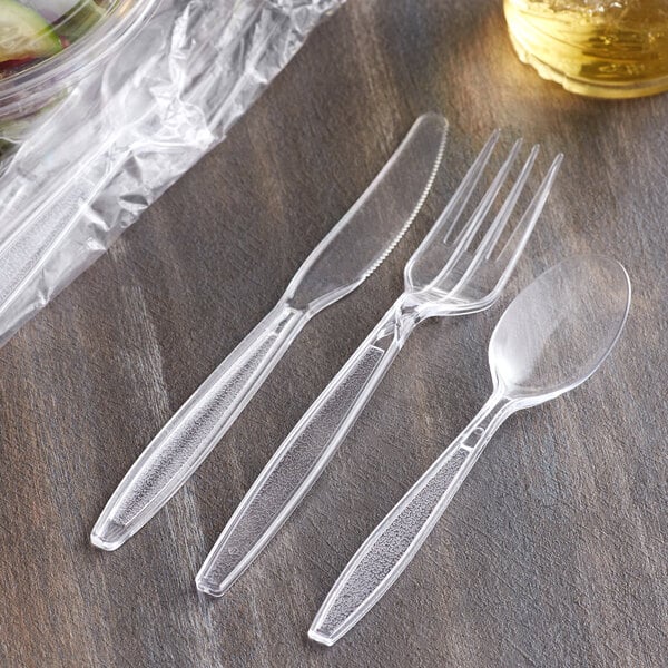 A wrapped clear plastic spoon, fork, and knife.