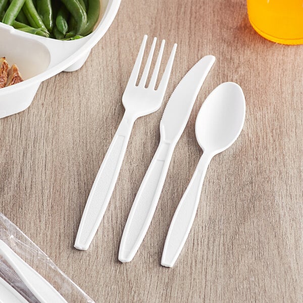 A white plastic wrapped cutlery pack with a fork, spoon, and knife.