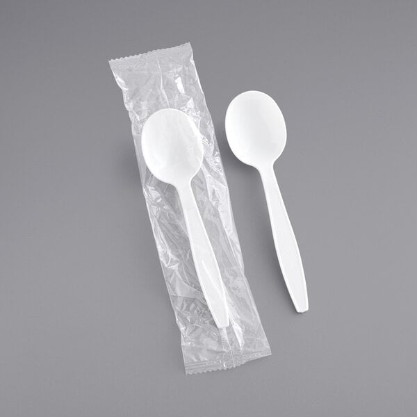 A white heavy weight plastic soup spoon in a plastic wrapper.
