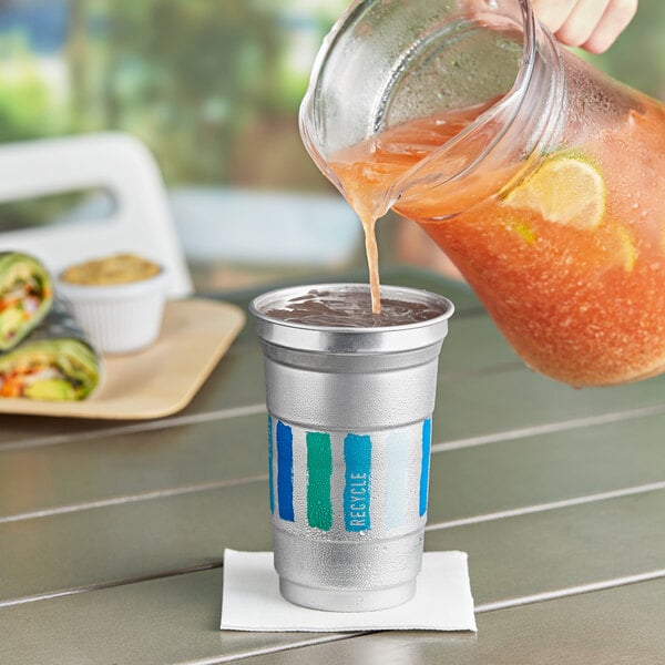 A person pouring a drink into a Ball aluminum cup with an everyday logo.