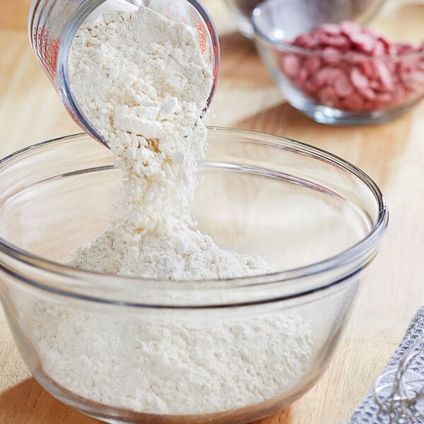 A person pouring ADM Pastry Flour into a glass bowl.