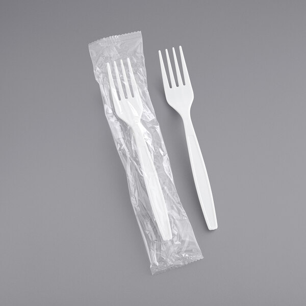 A white heavy weight plastic fork in plastic wrap.