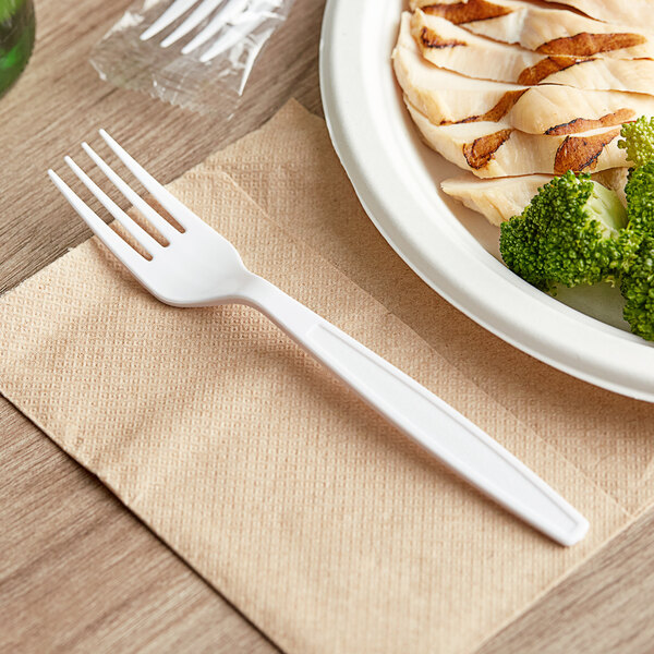 A wrapped white heavy weight plastic fork on a plate of chicken and broccoli.