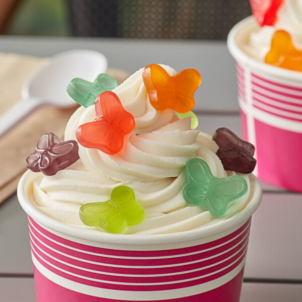 A cup of ice cream with Albanese gummi butterfly candy on top.