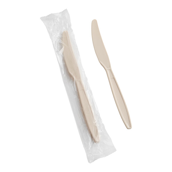 A beige heavy weight polystyrene plastic knife, with one shown individually and one wrapped in plastic.