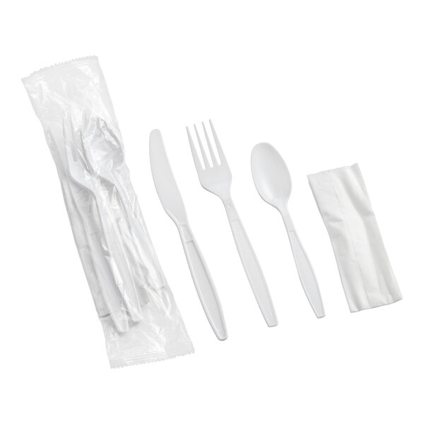 A set of white heavy weight plastic cutlery including a knife, fork, spoon, and a napkin, with an additional wrapped pack.
