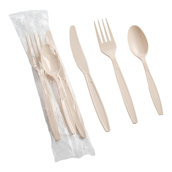 A set of beige heavy weight polystyrene plastic cutlery including a fork, knife, and spoon, with some pieces individually wrapped in plastic.