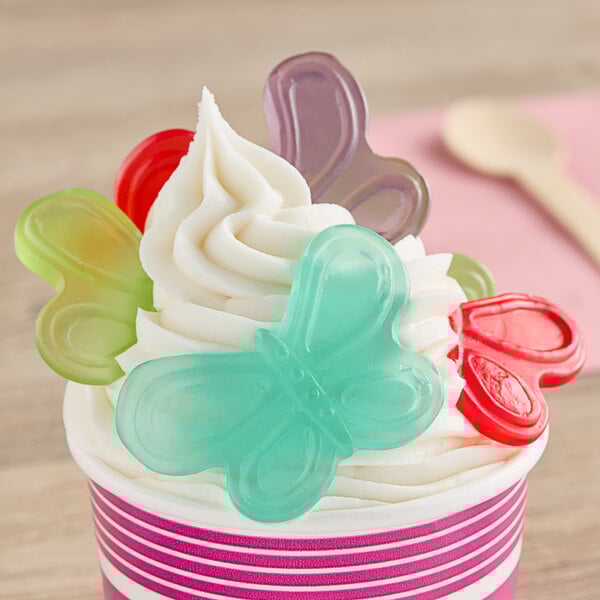 A cup of ice cream with Albanese gummi butterfly candy on top.