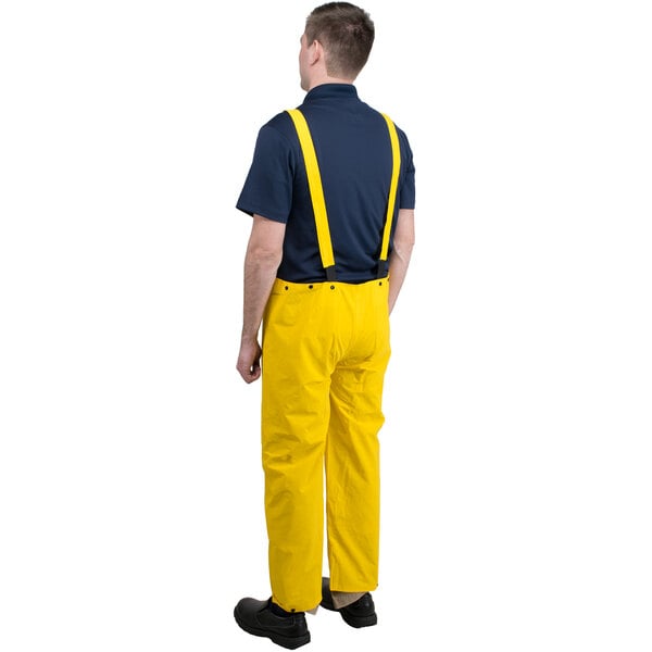 A man wearing yellow Cordova overalls and suspenders.