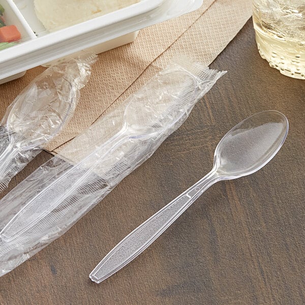 A plastic container of plastic-wrapped Choice Clear Heavy Weight Teaspoons.