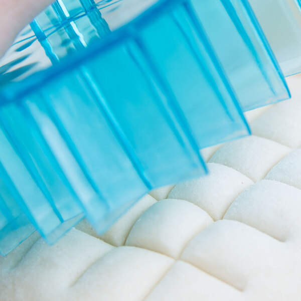 A blue plastic Ateco Mexican bread stamp with a waffle design.