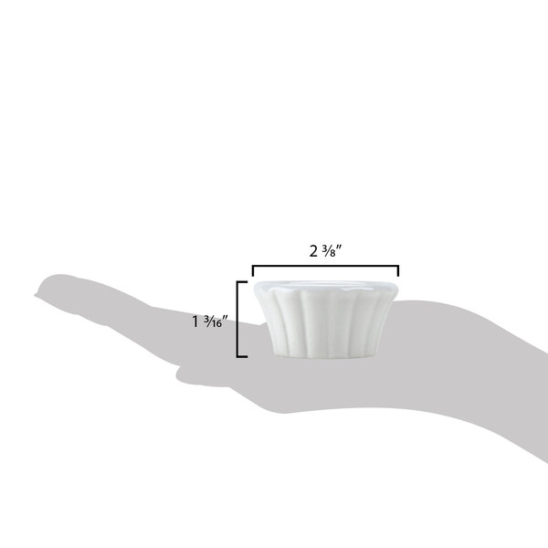 A hand holding a small white flared bowl.