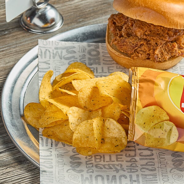 A plate with a sandwich and Lay's Cheddar Jalapeno Potato Chips on it.