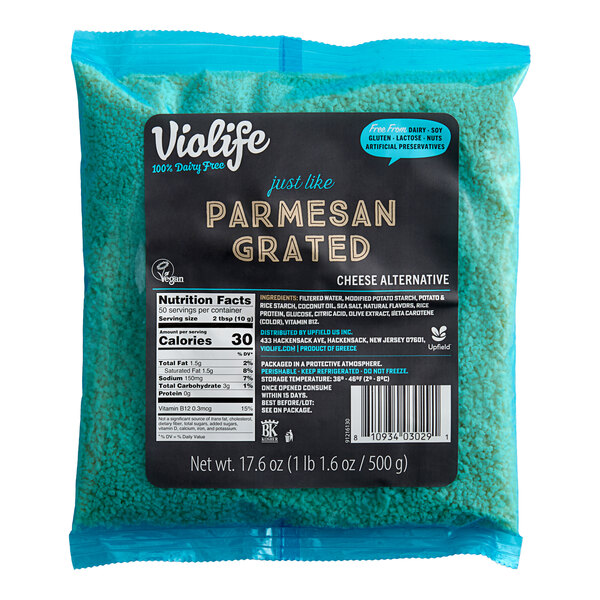 A package of Violife Just Like Parmesan Vegan Grated Cheese on a blue surface with a label.