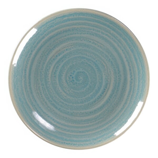 A close-up of a blue and white RAK Porcelain plate with swirls.