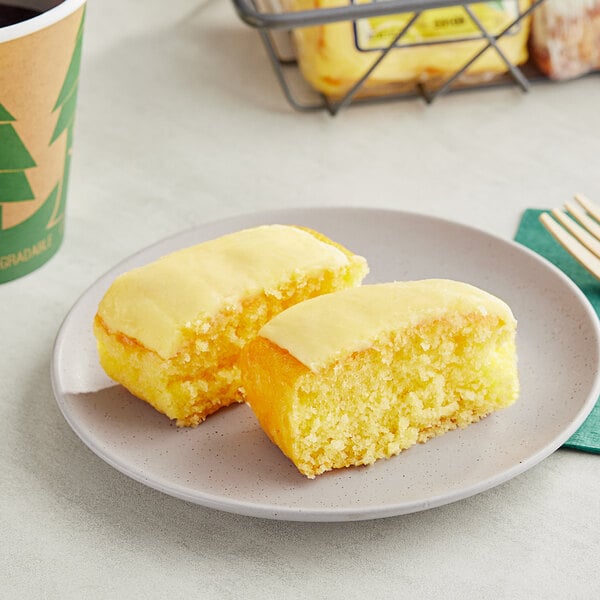 A white plate with two Ne-Mo's Bakery lemon cake squares on it.