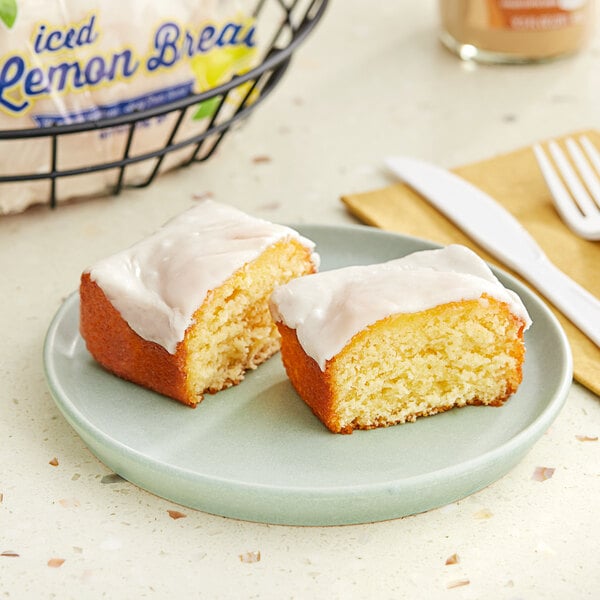 A piece of Ne-Mo's Bakery Iced Lemon Cake with white frosting on a plate.