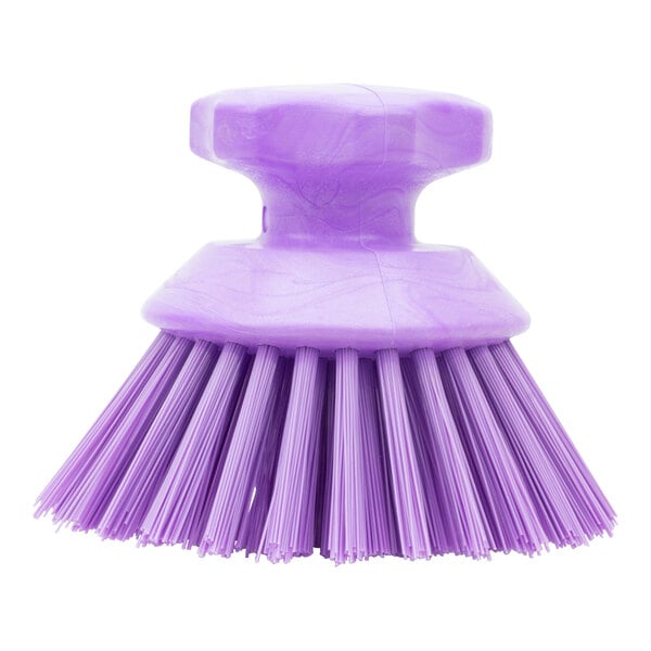 A purple round palm scrub brush with long bristles.