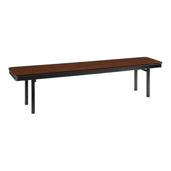 A National Public Seating Montana Walnut plywood folding bench with black legs.