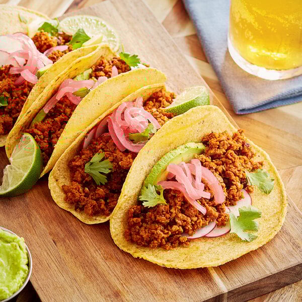 A group of tacos with Abbot's Butcher Plant-Based Vegan Chorizo crumbles on a wooden board.